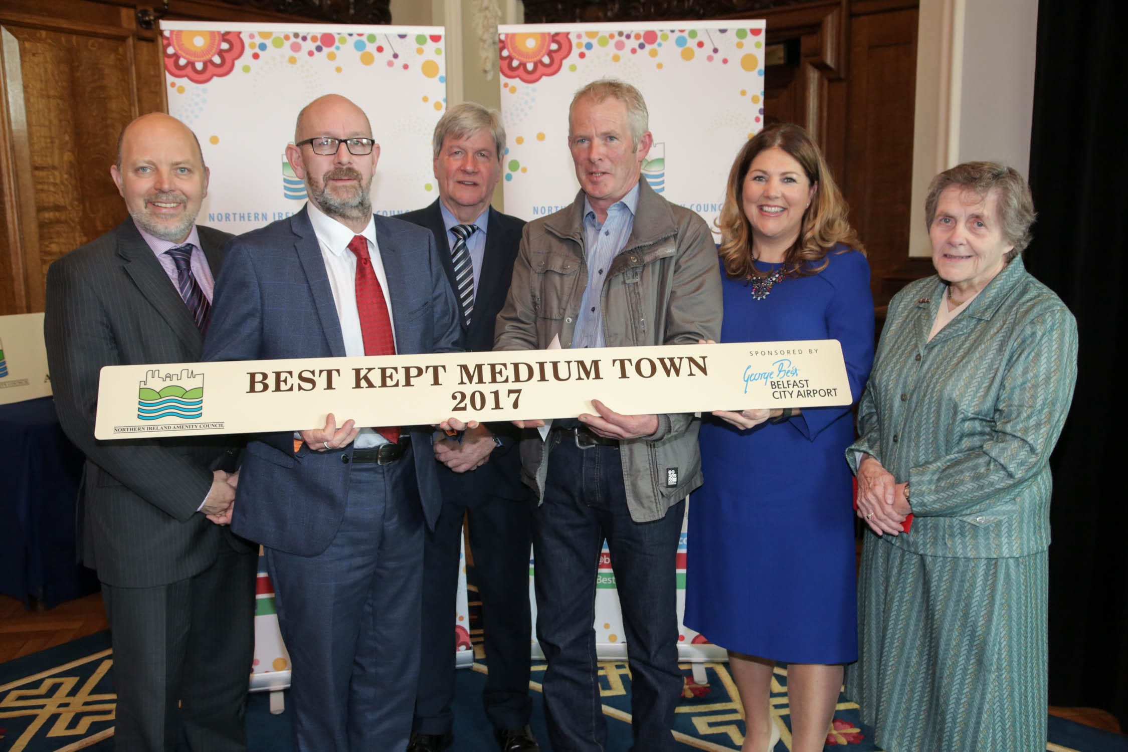 Winner in the Best Kept Medium Town Category of the NI Best Kept Awards is Armagh. Dave Foster, Department of Agriculture, Environment and Rural Affairs, Joe Mahon, Patron of the NI Amenity Council, Michelle Hatfield, Human Resources and Corporate Responsibility Director at Belfast City Airport and Doreen Muskett, President of the NI Amenity Council, present Armagh, Banbridge, Craigavon Council representative Barry Patience and Martin Kearns with their award. The judges noted that the strong historical connection of Armagh was beautifully realised by business people and residents who took pride in the town and its appearance.