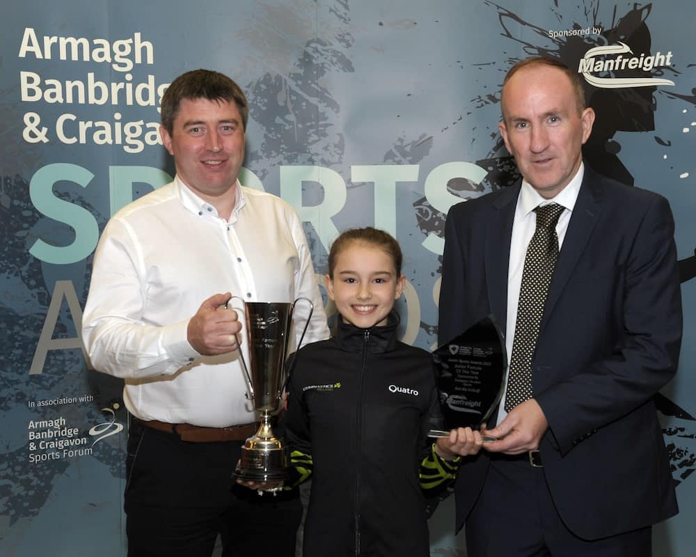 Estella Volkoff from Salto Gymnastics Club wins the Junior Female Award sponsored by Donaghy’s Shoefair Sports. Peter McVeigh from Donaghy’s Shoefair Sports and Francis Reynolds from Armagh, Banbridge and Craigavon Sports Forum present the award.